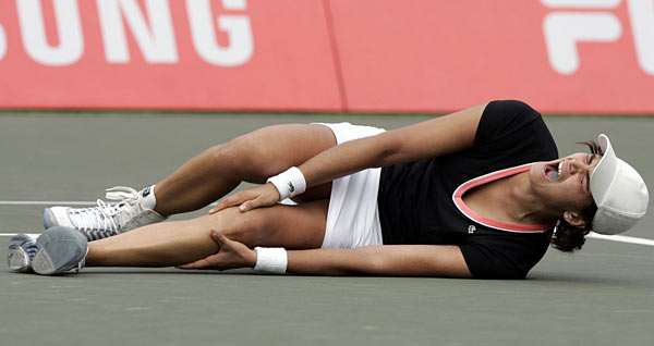 Eleni Daniilidou who is seized by a cramp on her left leg, falls on the floor after she beat Japan's Ai Sugiyama at the final match of the Hansol Korea Open Tennis Championships in Seoul October 1, 2006